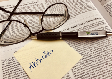 Auf einer Zeitung liegen eine Lesebrille, ein Kugelschreiber und eine post-it Notiz mit der Aufschrift 'Aktuelles'