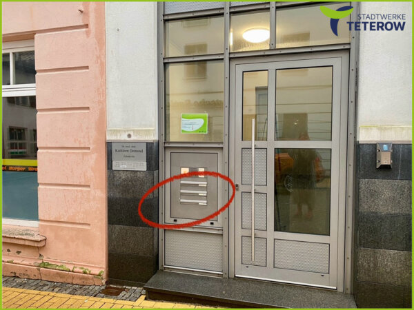 Eingangstür mit Briefkastenanlage, ein Briefkastenschlitz ist rot eingekreist - Hinweis der Stadtwerke Teterow zu einem eigenen Briefkasten neben dem Hauseingang.